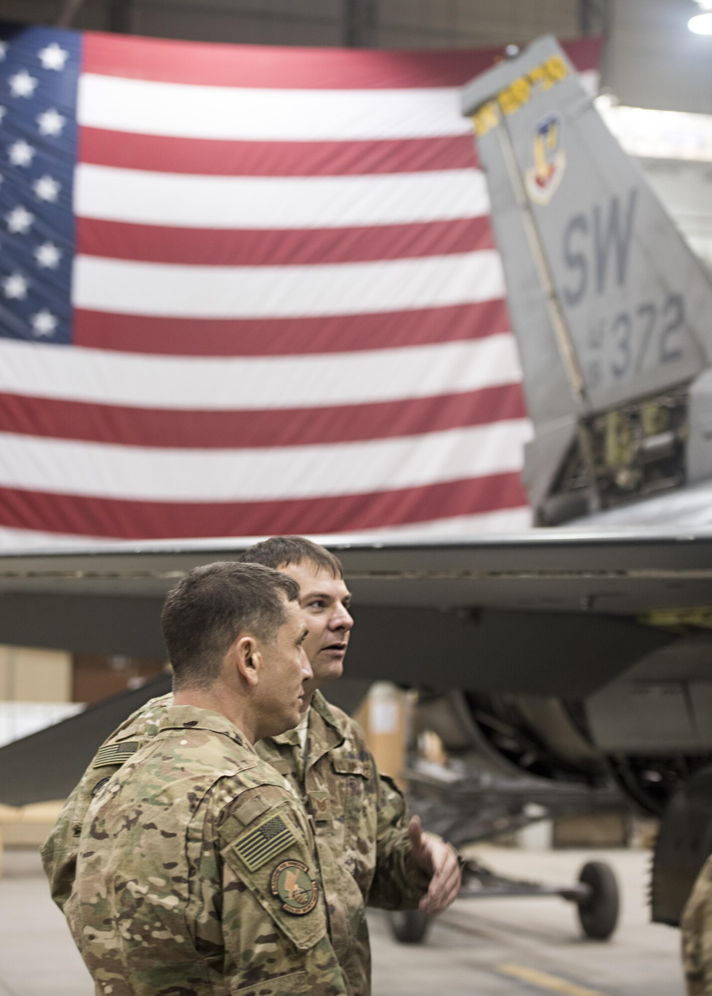 U.S. Air Forces Central Command Chief Master Sgt. Joseph Montgomery speaks to Tech. Sgt. Michael Rainer, 455th Expeditionary Aircraft Maintenance Squadron phase dock chief, about F-16 Fighting Falcon phase maintenance during a visit to Bagram Airfield, Afghanistan, Dec. 23, 2016. Montgomery had a robust schedule, including visits to nearly every 455th Air Expeditionary Wing unit. (U.S. Air Force photo by Staff Sgt. Katherine Spessa)