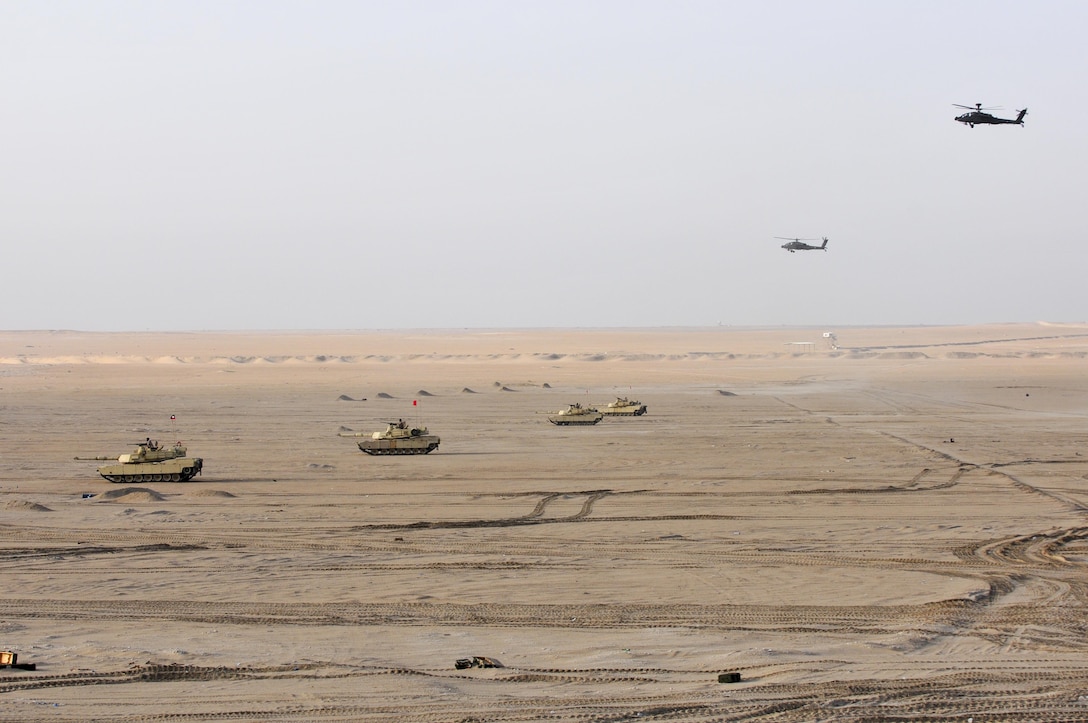 M1A2 Abrams Main Battle Tanks move to engage targets during a joint combined arms live-fire exercise near Camp Buehring, Kuwait Dec. 6-7, 2016. The multi-day exercise was designed to test the efficiency of the U.S. Army and Kuwaiti Land and Air forces abilities to identify and eliminate enemies’ anti-aircraft capabilities. Around 30 M1 Abrams Main Battle Tanks, two Kuwaiti AH-64 Apache helicopters, several Bradley Armored Fighting Vehicles, scout sniper teams, 120mm mortar teams, and M109 Self Propelled Howitzer artillery fire assaulted mock enemy positions during the exercise. (U.S. Army photo by Sgt. Aaron Ellerman)