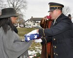 New York Army National Guard Spc. Ramon Rodriquez presents a U.S. Flag to Tammy Haynes, daughter of Army veteran Osborne Haynes, during his burial at Evergreen Memorial Park in Schenectady, N.Y., on Dec. 20, 2016. Haynes served in the U.S. Army from 1966-68. 