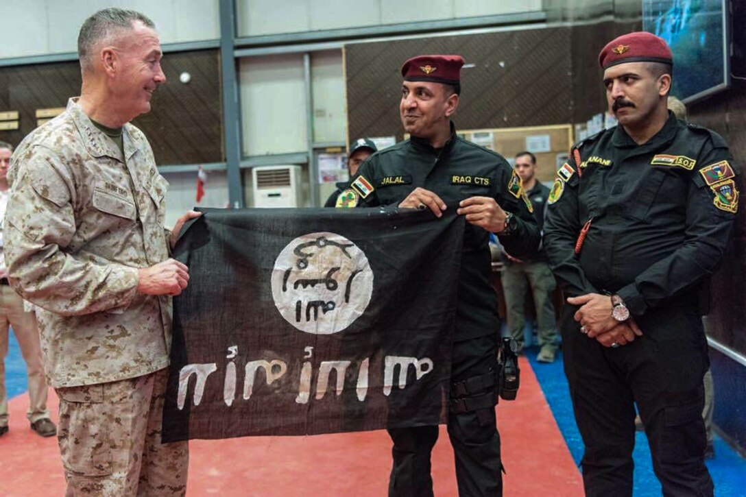 Members of the Iraqi Counter Terrorism Service present Gen. Joseph F. Dunford, chairman of the Joint Chiefs of Staff, a flag from Bartilah, a town recaptured by the Iraqi army just outside of Mosul from the Islamic State of Iraq and the Levant. The flag symbolizes the commendable efforts of Combined Joint Task Force-Operation Inherent Resolve composed of members from the Department of Defense and coalition military forces. (DoD photo by Mass Communications Specialist 2nd Class Dominique Pineiro)