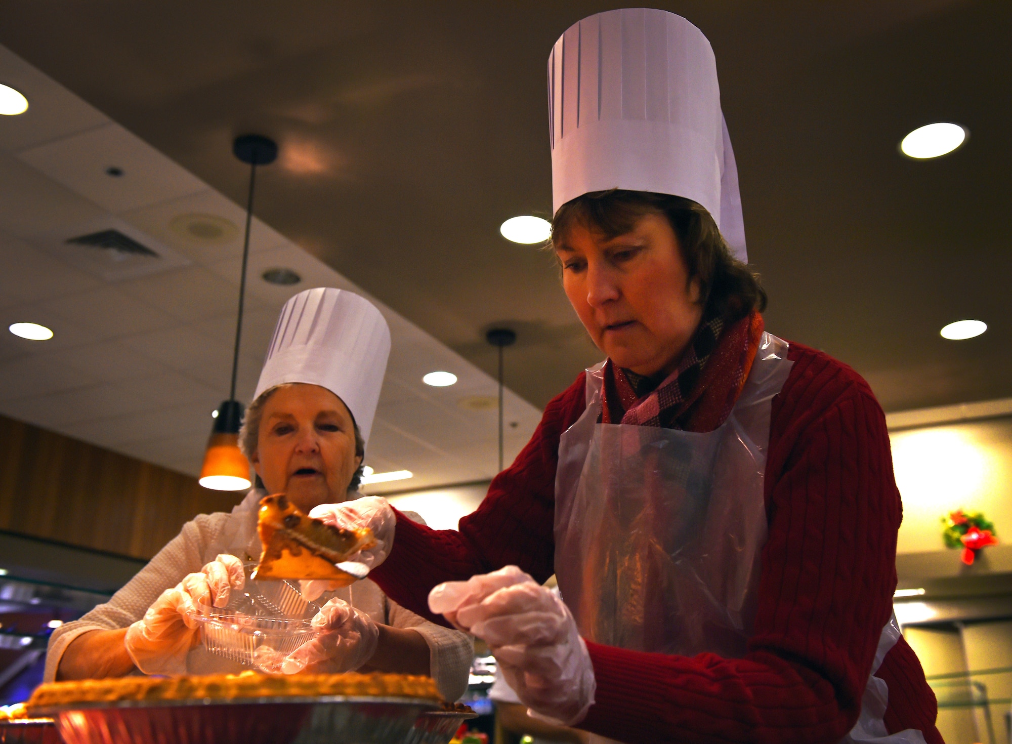 Lea Atchley and Pat Savage serve pie slices at the Iditarod Dining Facility at Joint Base Elmendorf-Richardson, Alaska, Dec. 25, 2016. Members of JBER leadership volunteered, in 30 minute intervals, to serve meals during Christmas. 