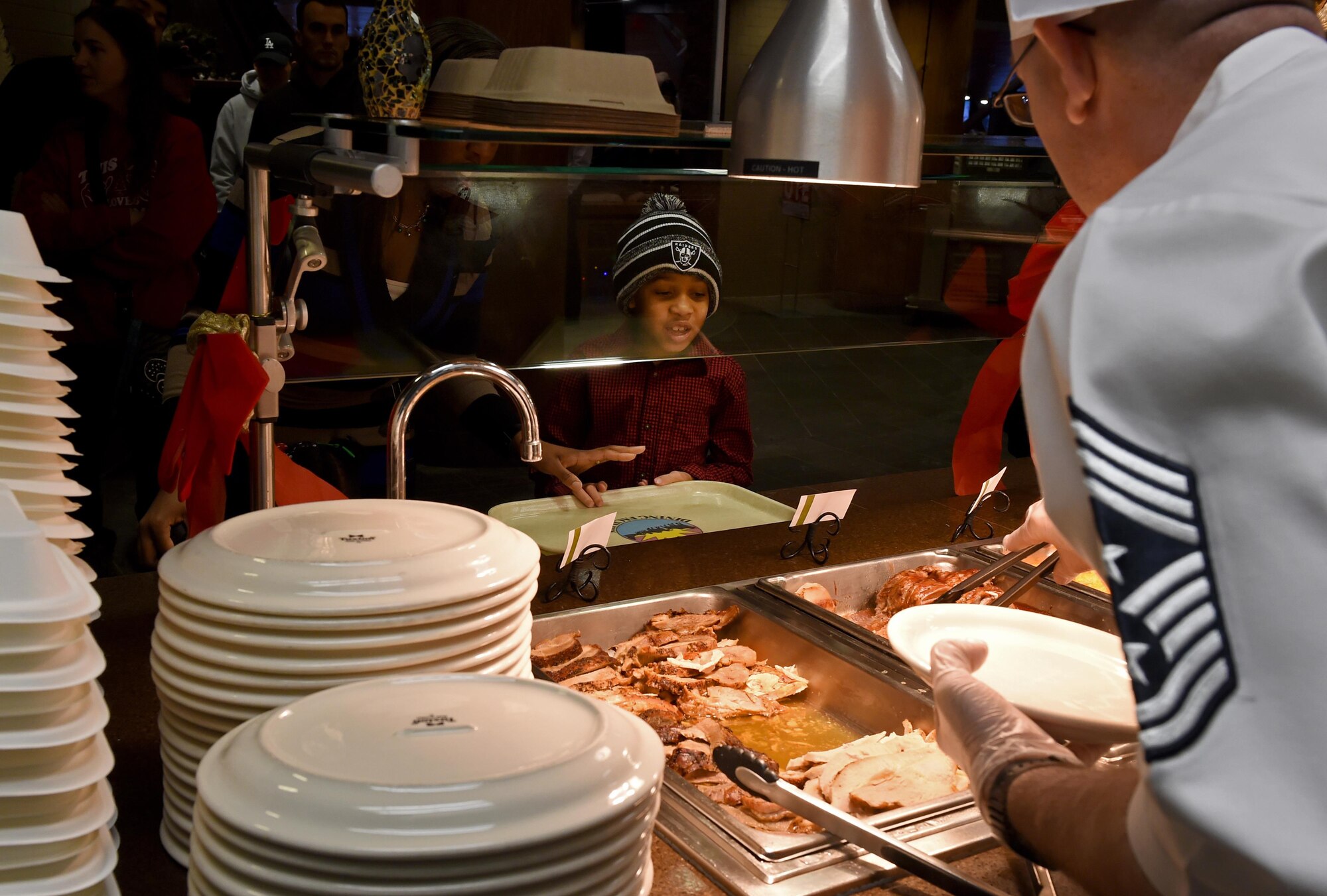 Chief Master Sgt. Garry Berry, 673d Air Base Wing command chief, serves up some holiday turkey to an Iditarod Dining Facility patron at Joint Base Elmendorf-Richardson, Alaska, Dec. 25, 2016. Every year, for Christmas and Thanksgiving, JBER leadership show their appreciation for the base community by serving holiday meals. 