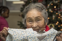 Chiyo, a Japanese elder, holds a gift from Misawa Airmen and families at the Harunaoka Old Age Home, Misawa City, Japan, Dec. 22, 2016. Chiyo celebrated her birthday for turning 84-years-old in December. The facility helps care for elderly in need by providing food and shelter. (U.S. Air Force photo by Airman 1st Class Sadie Colbert)