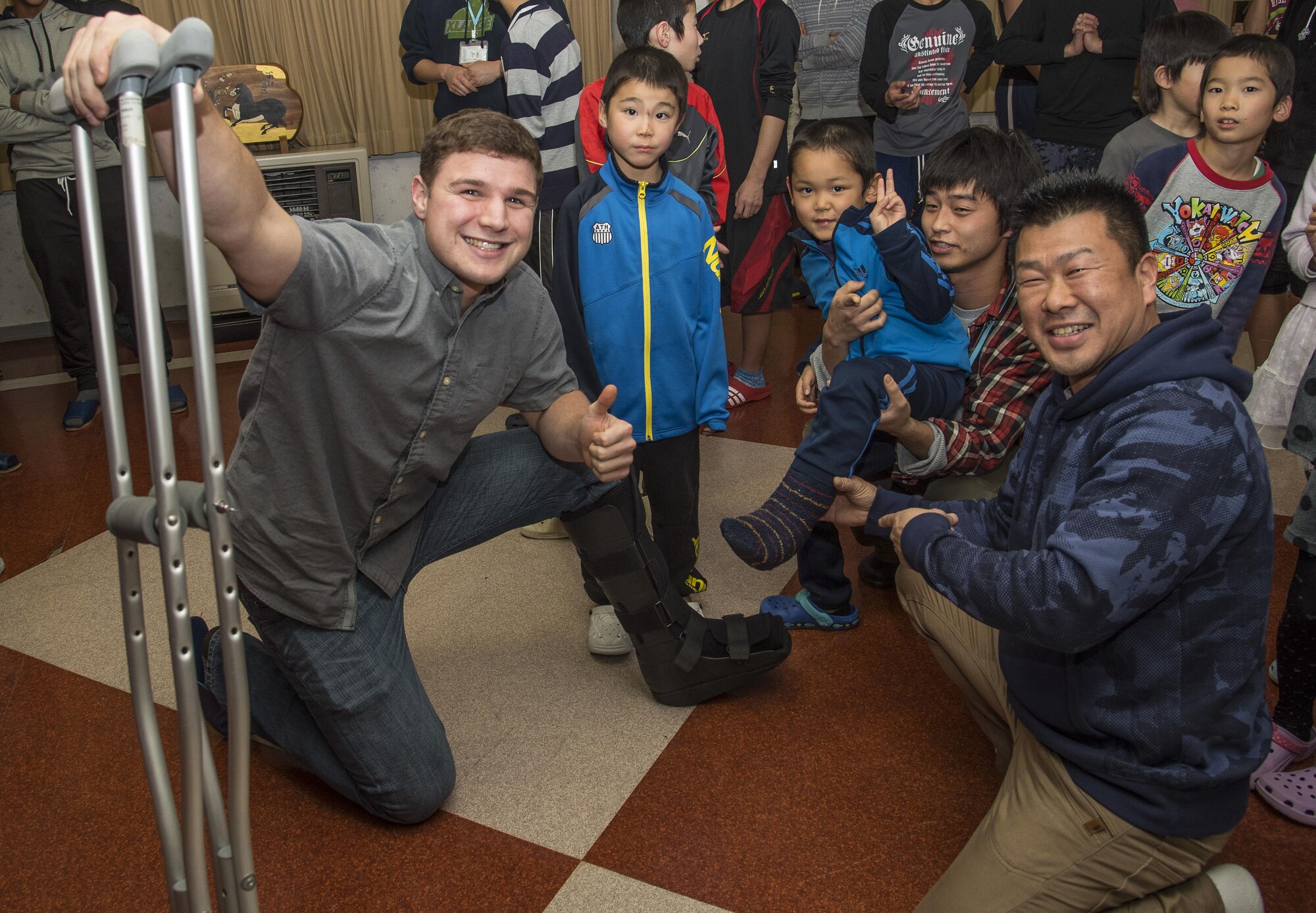 U.S. Air Force Airman Russel Plunkey, left, a 35th Civil Engineer Squadron pavements and equipment technician, poses with Yuussei, a Shichinohe Orphanage member, to show their boots at Shichinohe, Japan, Dec. 23, 2016. The squadron brought gifts to each orphan as well as donated a flat screen TV and a Wii gaming system to the facility. (U.S. Air Force photo by Airman 1st Class Sadie Colbert)
