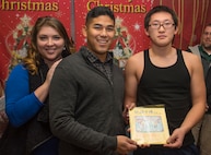 Kennedy Travis, left, wife of U.S. Air Force Senior Airman Lowell Travis, center, the 35th Civil Engineer Squadron heavy planner, accept a thank you card from Daiki Komata, a Shichinohe Ophanage member, at Shichinohe, Japan, Dec. 23, 2016. The 35th Civil Engineer Squadron Airmen gave 41 gifts to orphans who ranged from 2-years-old to 18-years-old. (U.S. Air Force photo by Airman 1st Class Sadie Colbert)