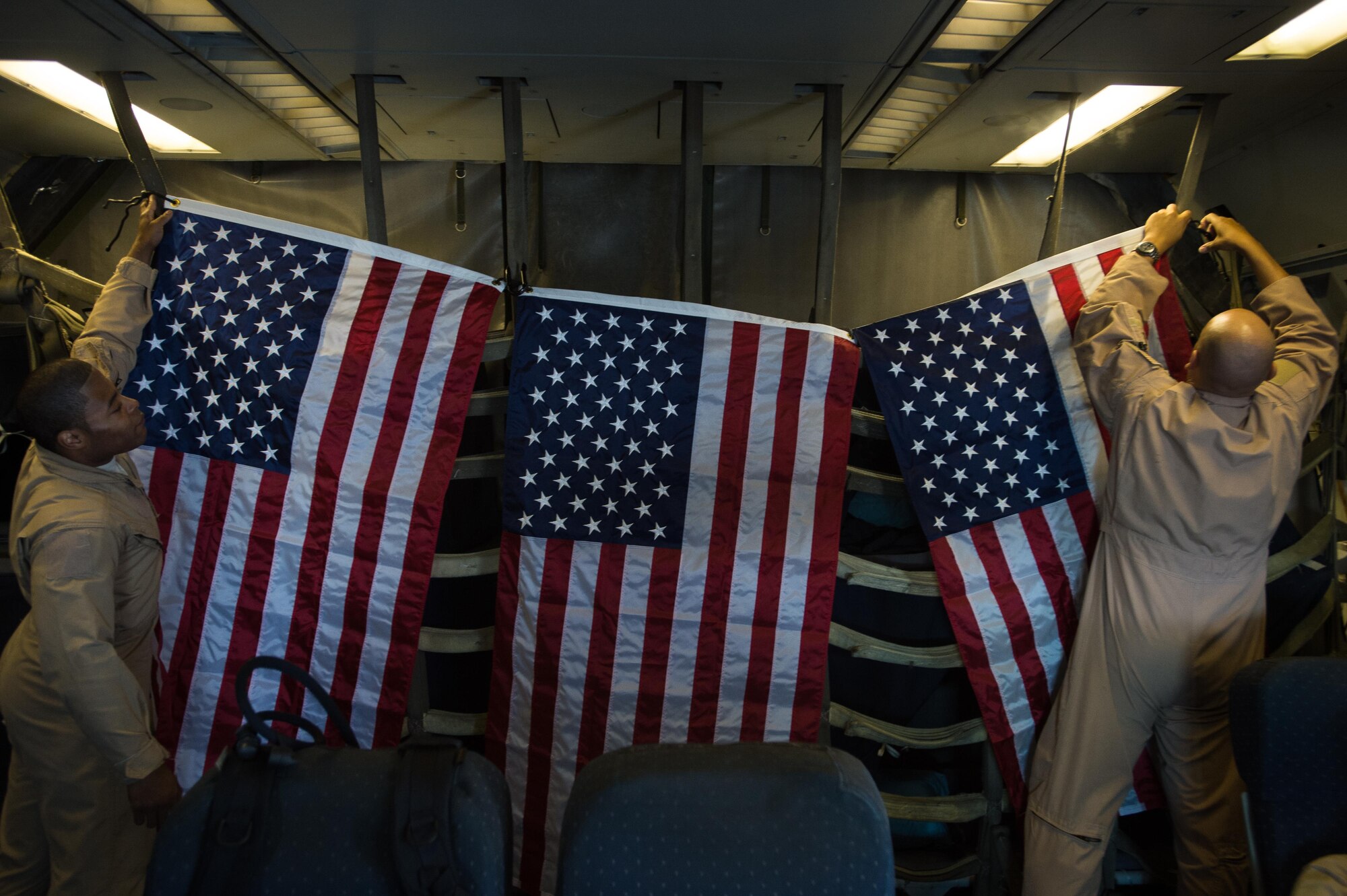 380th Air Expeditionary Wing KC-10 Extender crew members secure U.S. flags before flying a sortie in support of Combined Joint Task Force-Operation Inherent Resolve at an undisclosed location in Southwest Asia, Dec. 25, 2016. The flag flying program allows service members to share U.S. flags flown in current operations as gifts or memorabilia. (U.S. Air Force photo/Senior Airman Tyler Woodward)