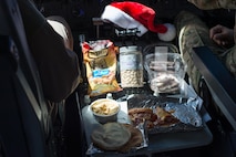 An aircrew eats a holiday meal while flying a sortie in support of Combined Joint Task Force-Operation Inherent Resolve over Iraq, Dec. 25, 2016. During the flight the crew snacked on oven-ready chicken nuggets, pizza and pita bread.  (U.S. Air Force photo/Senior Airman Tyler Woodward)
