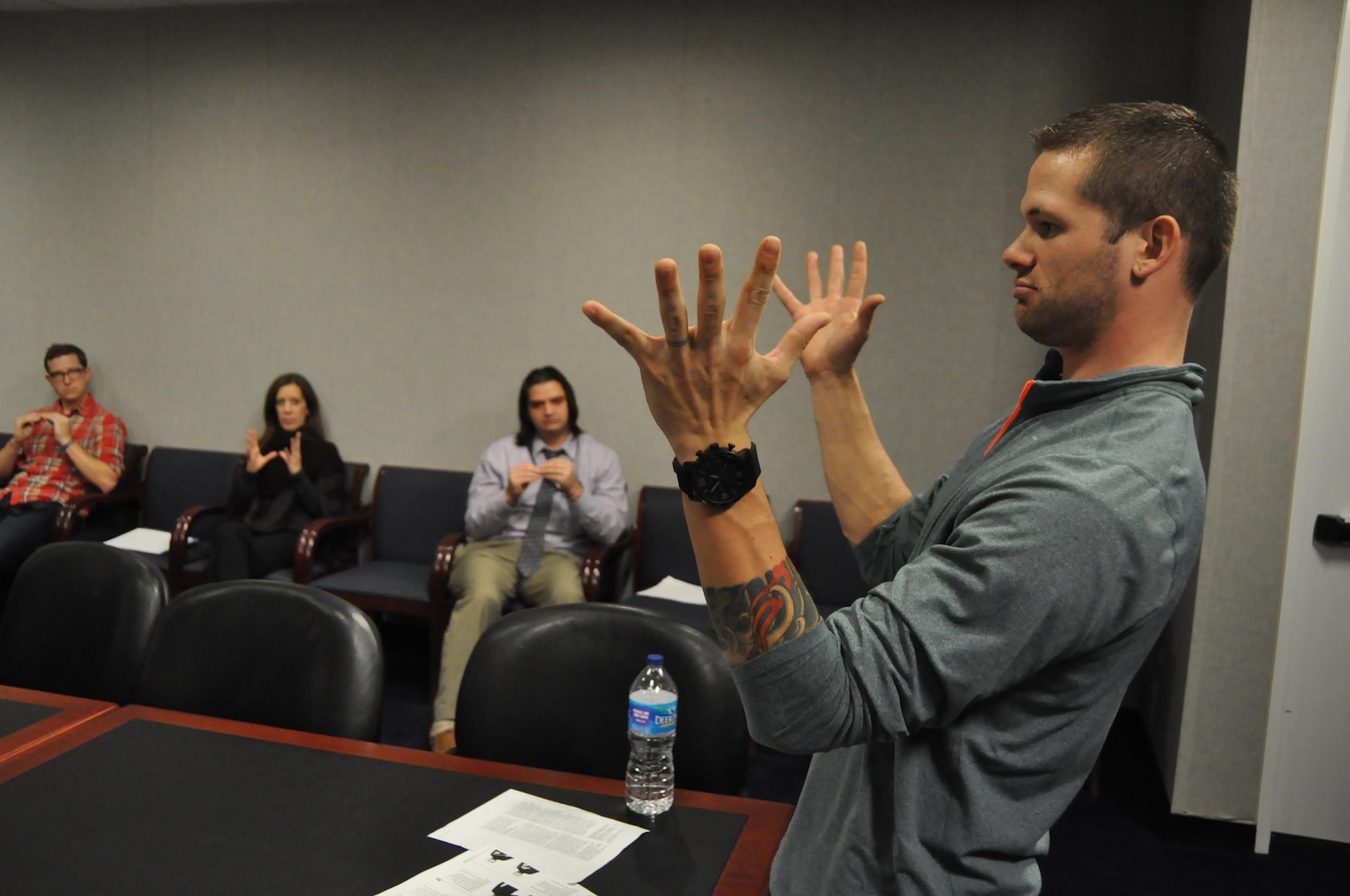 Jarvis Beaver, a business analyst in DLA Energy, uses expressive body language to teach agency students American Sign Language. 