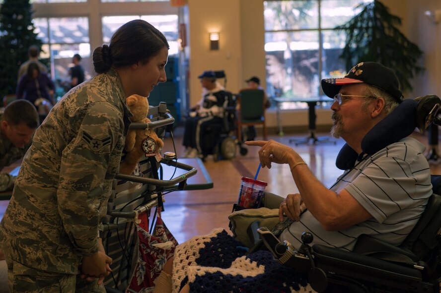 Airman 1st Class Maygan Straight, combat broadcaster with 1st Combat Camera Squadron, Joint Base Charleston, S.C., speaks with retired Air Force Chief Master Sgt. Ron Evans during a visit to the Veterans Victory House, Walterboro, S.C., Dec. 2, 2016. Members of the Air Force Sergeants Association and volunteers gather annually to support local Veterans during the holiday season. (U.S. Air Force Photo by Staff Sgt. Amy Picard)