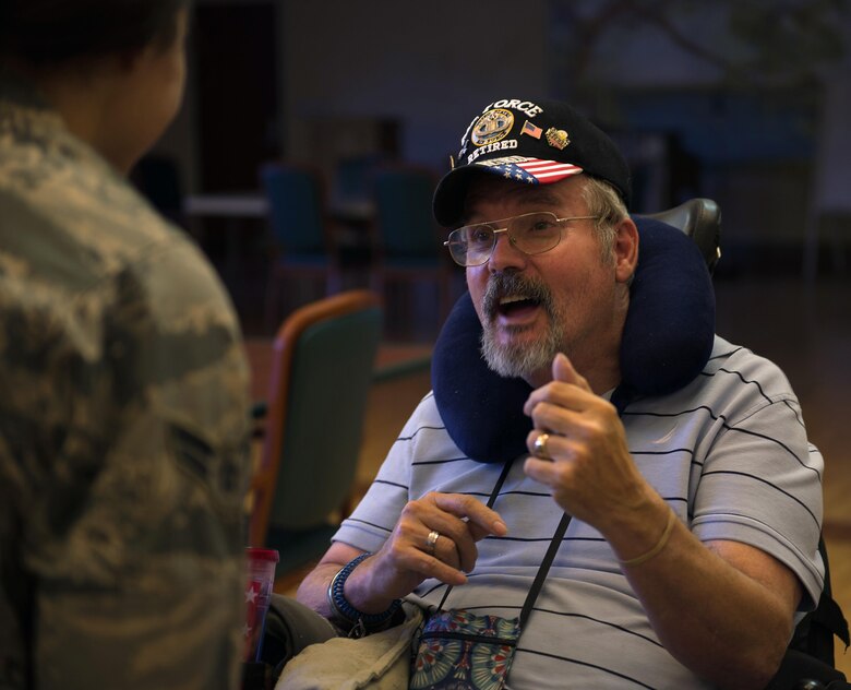 Airman 1st Class Maygan Straight, combat broadcaster with 1st Combat Camera Squadron, Joint Base Charleston, S.C., speaks with ret. Air Force Chief Master Sgt. Ron Evans during a visit to the Veterans Victory House, Walterboro, S.C., Dec. 2, 2016. Members of the Air Force Sergeants Association and volunteers gather annually to support local Veterans during the holiday season. (U.S. Air Force Photo by Staff Sgt. Amy Picard)