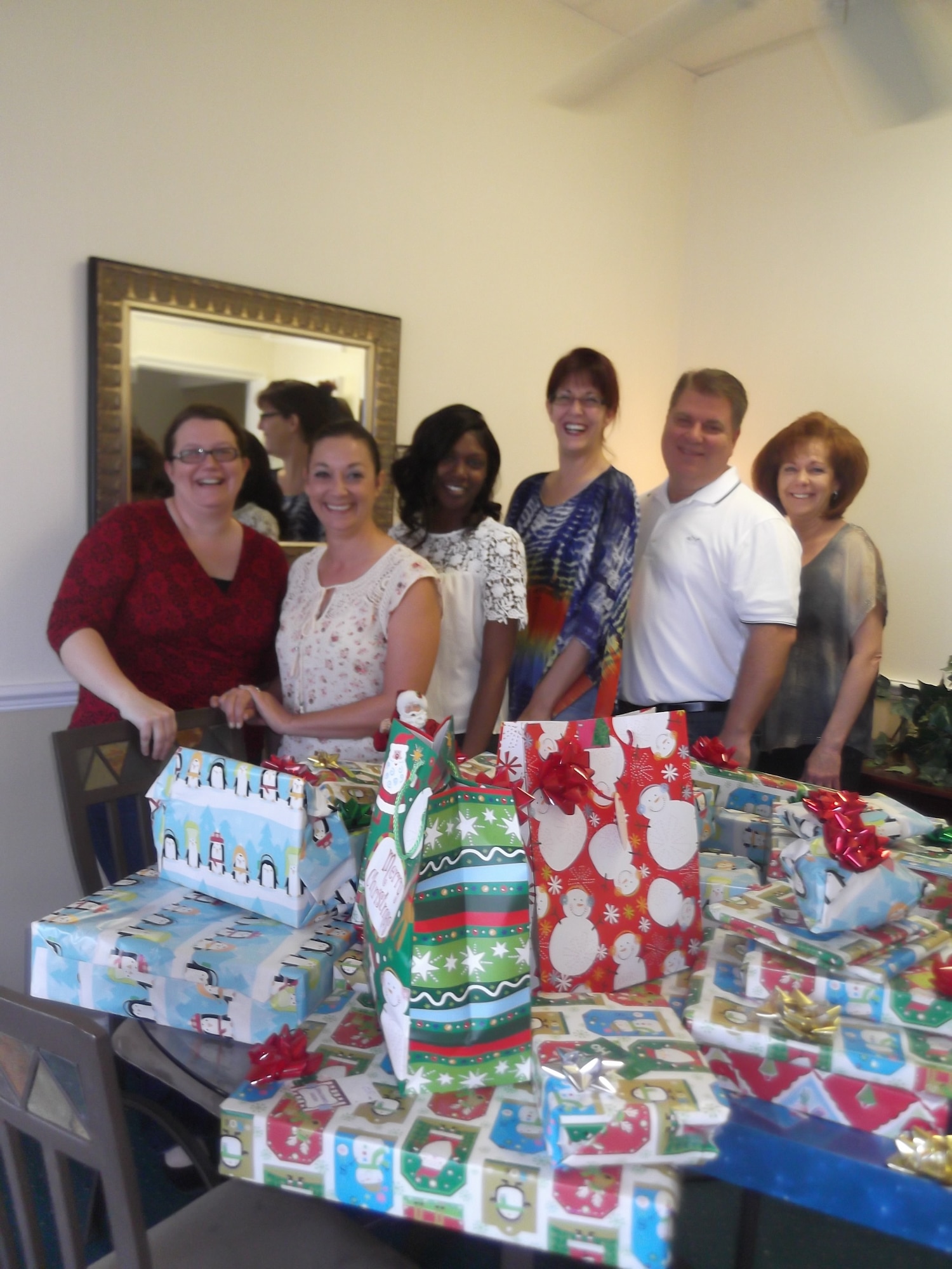 (From left) Stacy Brown, Allyson Agner, Diamond Armour, Diana Demetski, Jeffrey Miller and Tracy Bucher, Vintage Real Estate Company, Brandon, Florida, delivers holiday cheer to the 927th Air Refueling Wing. During the holiday season, the 927th Air Refueling Wing Airman Family Readiness Office here, represented by Master Sgt. Marchell Green(on left) creates a Wingman Tree, a tree that Wing members can select an angel representing an Airman and his or her family that are in need, this year the local community also helped answer the need. (Courtesy photo) 