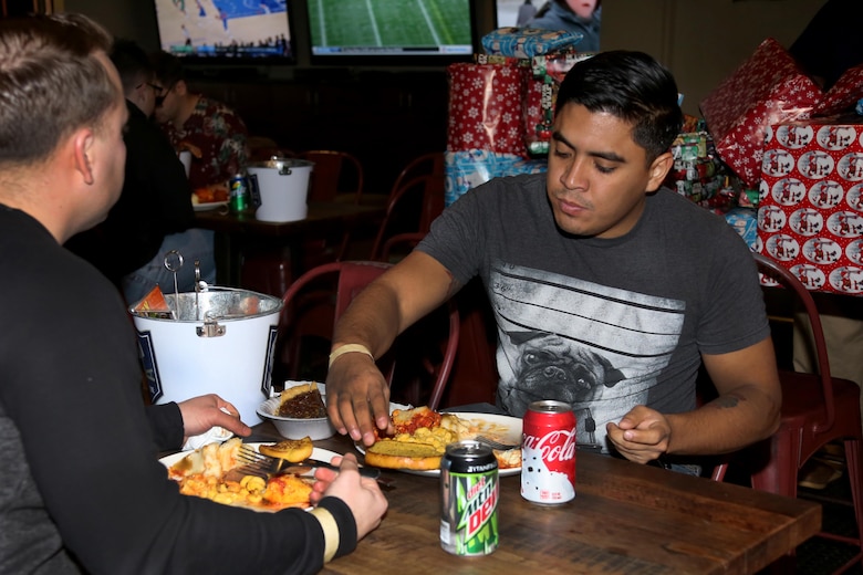 Sgt. Daniel Escajeda eats an Italian-style meal during the Single Marine Program’s annual Christmas dinner at the Roadhouse aboard Marine Corps Air Station Cherry Point, N.C., Dec. 25, 2016. The free homemade dinner was open to all single and unaccompanied Marines and Sailors. Activities went on all day at the Roadhouse to include holiday movies, a mega gingerbread house construction and white elephant gift exchange with gifts provided by the SMP. Escadeja is a field radio operator with Marine Wing Communications Squadron 28. (Marine Corps photo by Cpl. Jason Jimenez/ Released)