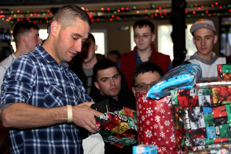 Pfc. Andrew Dixon opens a gift in the course of a white elephant gift exchange during the Single Marine Program’s annual Christmas dinner at the Roadhouse aboard Marine Corps Air Station Cherry Point, N.C., Dec. 25, 2016. The free homemade dinner was open to all single and unaccompanied Marines and Sailors. Activities went on all day at the Roadhouse to include holiday movies, a mega gingerbread house construction and white elephant gift exchange with gifts provided by the SMP. Dixon is a powerline mechanic with Marine Attack Squadron 542. (Marine Corps photo by Cpl. Jason Jimenez/ Released)