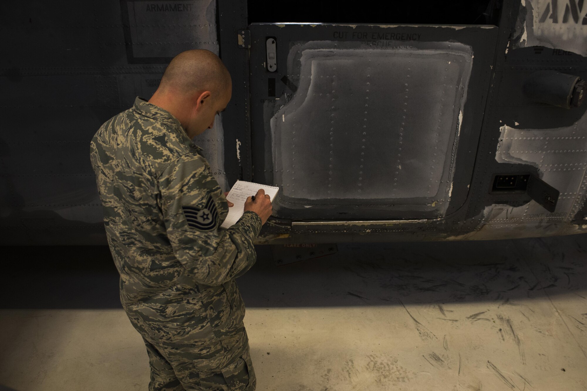 Tech. Sgt. David Desporte, 27th Special Operations Maintenance Squadron aircraft structural maintenance section chief, writes down notes while performing an initial assessment of a MH-53 Pave Low helicopter Oct. 31, 2016, at Cannon Air Force Base, N.M. The Pave Low was a multi-month restoration project the aircraft structural maintenance team worked on for a static display at Cannon AFB’s front gate. (U.S. Air Force photo by Senior Airman Luke Kitterman/Released)