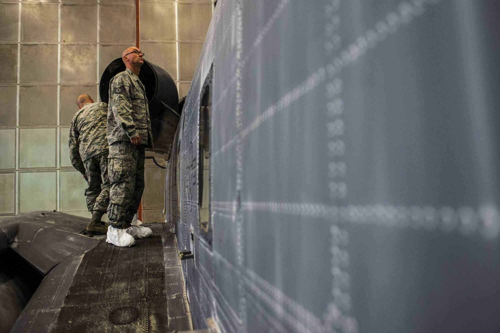 Tech. Sgt. George Mayo, 27th Special Operations Maintenance Squadron corrosion control NCO in charge, front, and Tech. Sgt. David Desporte, 27th SOMXS aircraft structural maintenance section chief, perform an initial assessment of a MH-53 Pave Low helicopter Oct. 31, 2016, at Cannon Air Force Base, N.M. The aircraft structural maintenance shop is responsible for repairing and ensuring structural integrity for all aircraft at Cannon. (U.S. Air Force photo by Senior Airman Luke Kitterman/Released)