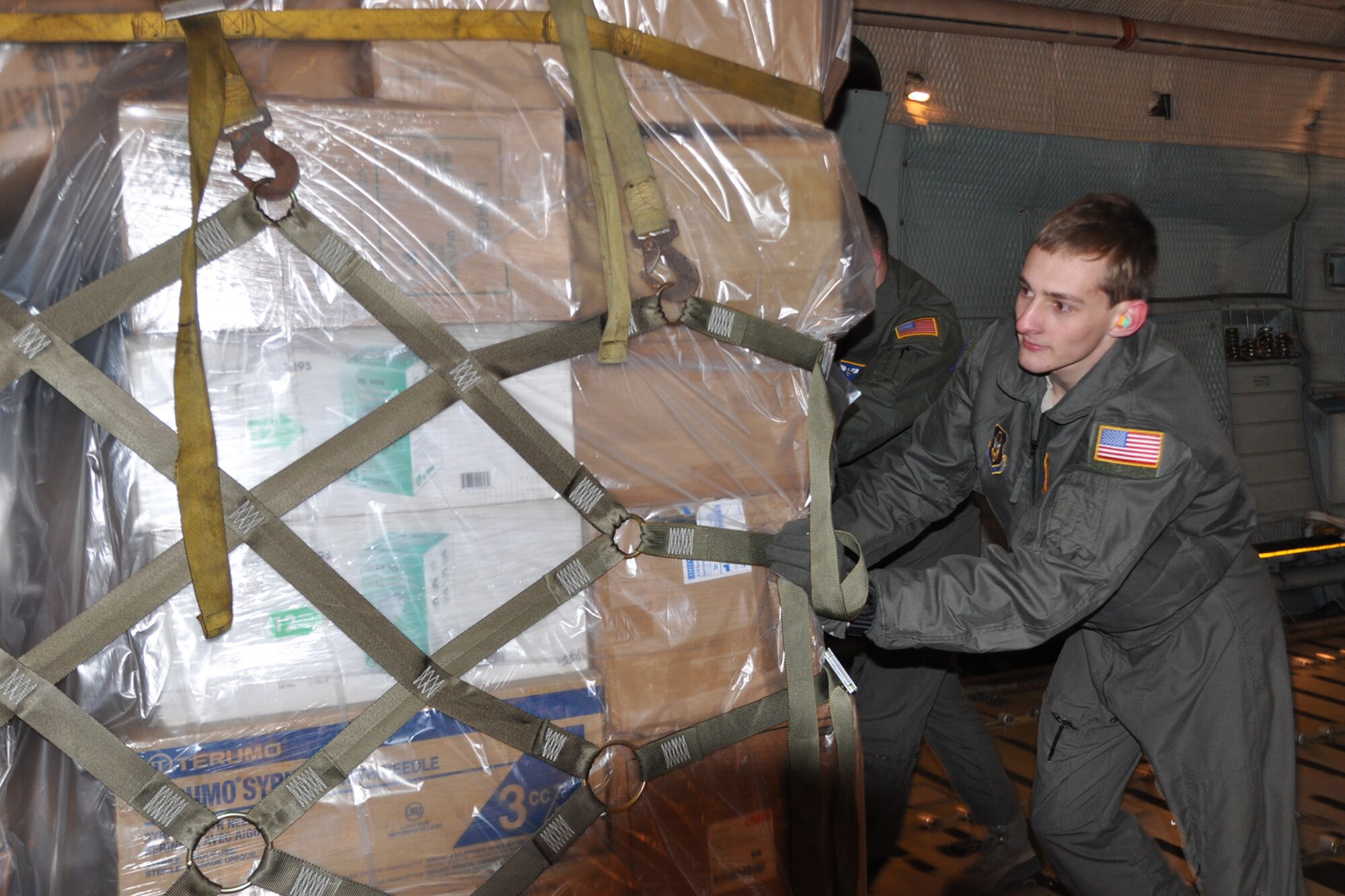 Senior Airman Nicholas Orcutt, a 757th Airlift Squadron loadmaster, assists with pushing a cargo pallet into place on a C-5 Galaxy cargo aircraft. The cargo was bound for Guatemala as part of a Denton cargo mission. The Denton program allows non-governmental organizations, such as the Austintown, Ohio-based Mission of Love Foundation, to use space available on military airlift aircraft to provide humanitarian aid to those in need worldwide. (U.S. Air Force photo/Maj. Polly Orcutt)
