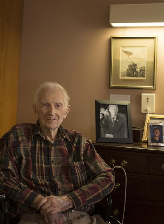 Retired 1st Lt. John J. O’Leary sits in front of his signed photo of the second flag-raising on Mt. Suribachi at the Evergreen Community of Johnson County, Olathe, Kan., Dec. 21, 2016. O’Leary was given the photo by the photographer Joe Rosenthal a week after the flag raising. O’Leary fought on Guam and witnessed the bombardment of Iwo Jima as a member of 3rd Joint Assault Signal Company. He celebrated his 100th birthday on Dec. 23.  (U.S. Marine Corps photo by Sgt. Ian Leones)