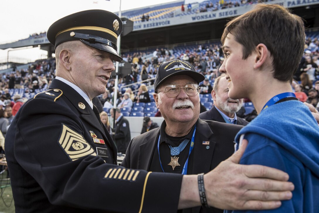 Army Command Sgt. Maj. John W. Troxell, left, senior enlisted advisor to the Chairman of the Joint Chiefs of Staff, meets a relative of Medal of Honor recipient Harvey C. "Barney" Barnum Jr. center, a retired Marine Corps officer, before conducting the coin toss during the 2016 Military Bowl at the Navy-Marine Corps Memorial Stadium in Annapolis, Md., Dec. 27, 2016. The Wake Forest Demon Deacons defeated the Temple Owls 34-26 during the college bowl, which benefits the USO and other organizations supporting the armed forces and their families. DoD photo by Army Sgt. James K. McCann<br /><br /><a target="_blank" href=https://www.flickr.com/photos/thejointstaff/albums/72157676535942612>Click here to see more images on the Chairman's Flickr page. </a>