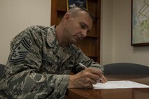 U.S. Air Force Chief Master Sgt. Michael Ditore, 18th Wing command chief, signs Senior Airman Below-The-Zone paperwork Dec. 13, 2016, at Kadena Air Base, Japan. Ditore makes Airmen his top priority as Kadena’s newest senior enlisted leader; building relationships and making differences in lives has been a goal of Ditore’s since his first day in the Air Force. (U.S. Air Force photo by Senior Airman Lynette M. Rolen/Released)