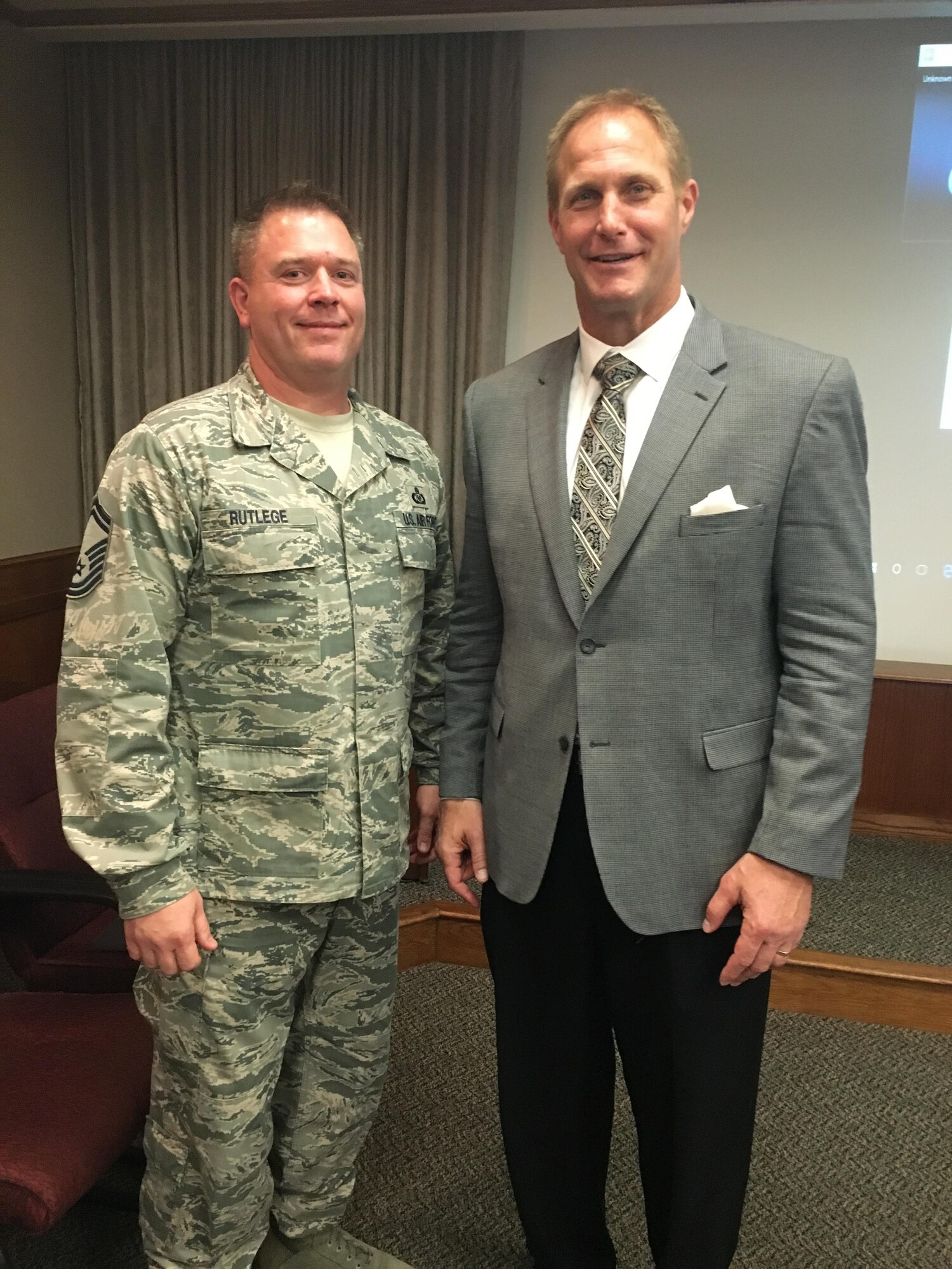 Senior Master Sgt. Brian Rutlege is congratulated on his selection to chief by former Dallas Cowboys player and Air Force A-10 pilot, Chad Hennings, at the Profession of Arms Center of Excellence Summit Dec. 7-8. The chief select is the Career Assistance Advisor at the 48th Fighter Wing, Royal Air Force, Lakenheath. (U.S. Air Force photo by Megan Hyman)