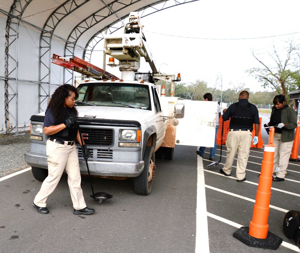 Members of the physical security team, at Marine Corps Logistics Base Albany, inspect a vehicle at the commercial truck entrance at Mock Road. According to the installation’s security officials, the physical security team, assisted by military working dogs, inspect between 100-200 commercial vehicles every day.