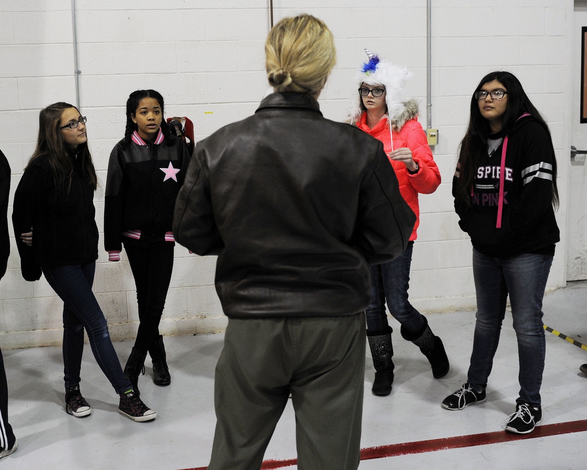 Capt. Katie Schuler, 16th Special Operations Squadron pilot, speaks to Portales High School Math Engineering and Science Achievement club members, Dec. 9, 2016, during a tour at Cannon Air Force Base, N.M.  The tour, which consisted of an AC-130 technology brief and an in-depth look at a powered-on AC-130W, was designed to give students a practical look at real world math, engineering and science applications. (U.S. Air Force photo by Staff Sgt. Whitney Amstutz/Released)