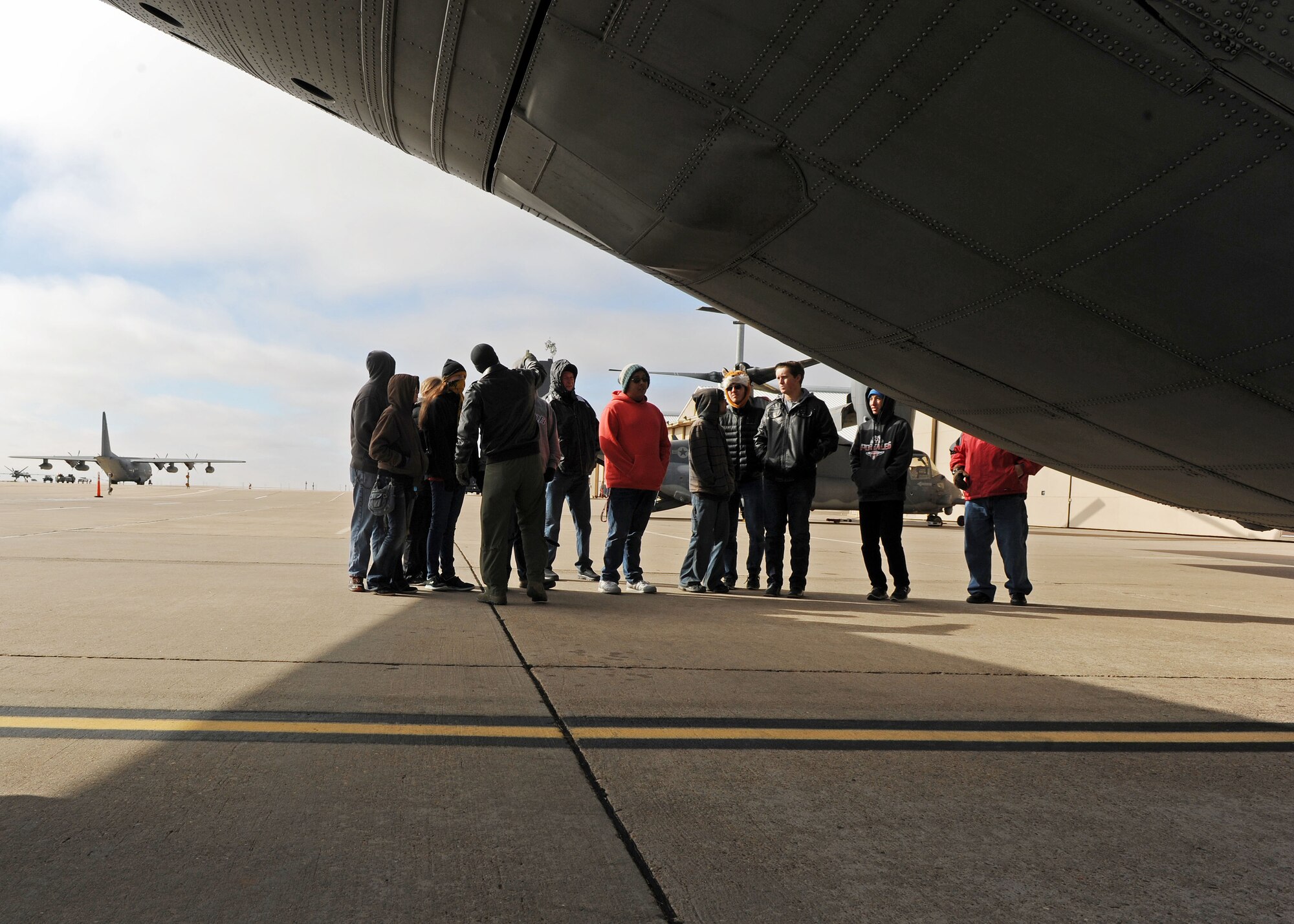 Capt. Daniel Sickles, 16th Special Operations Squadron Combat Systems officer, speaks to Portales High School Math Engineering and Science Achievement club members about the capabilities of an AC-130W, Dec. 9, 2016, during a tour at Cannon Air Force Base, N.M. The tour, which consisted of an AC-130 technology brief and an in-depth look at a powered-on AC-130W, was designed to give students a practical look at real world math, engineering and science applications. (U.S. Air Force photo by Staff Sgt. Whitney Amstutz/Released)