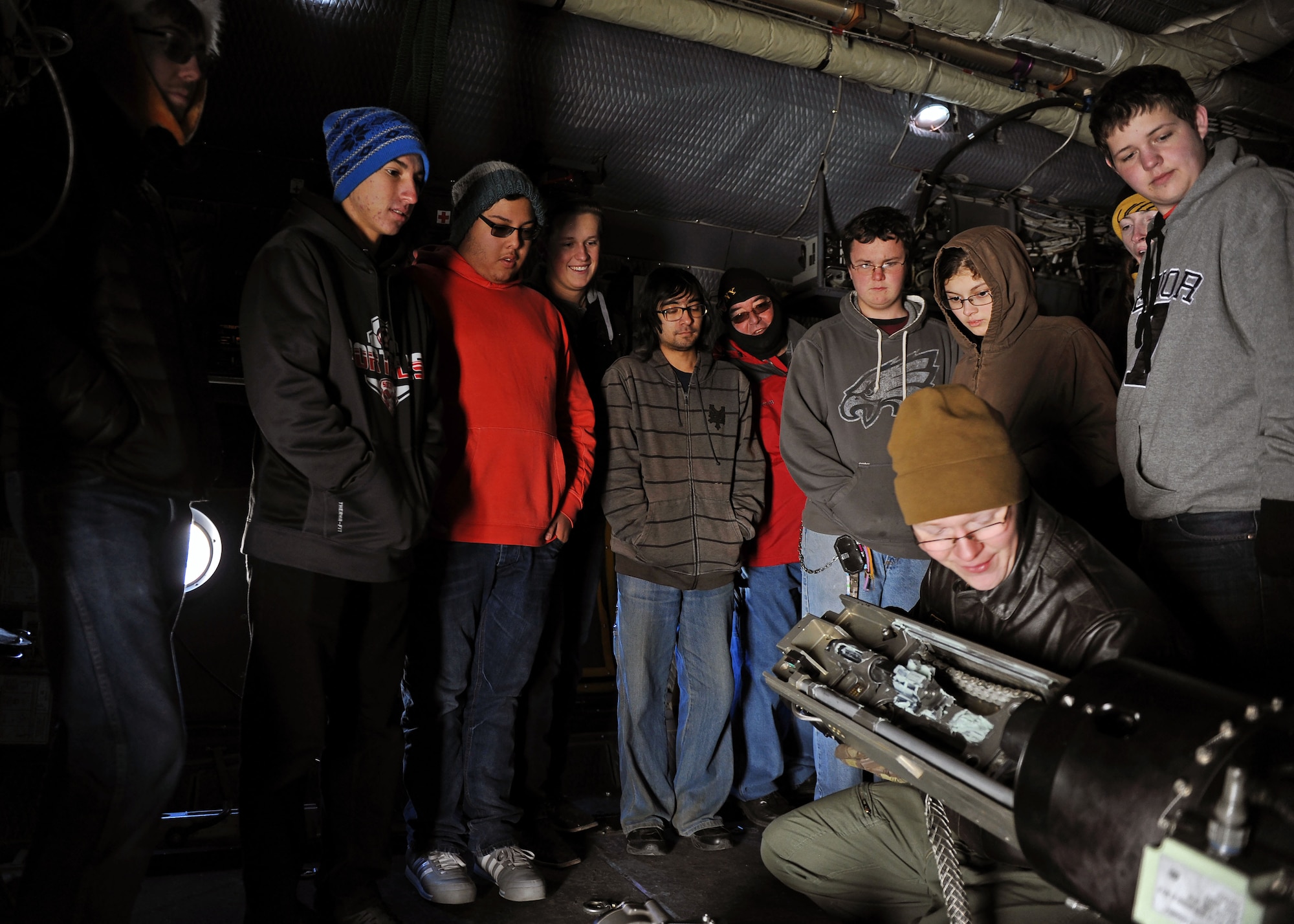 Senior Airman Nick Matthews, 16th Special Operations Squadron Special Missions aviator, reassembles a weapon system after breaking it down and explaining its operating system to Portales High School Math Engineering and Science Achievement club members, Dec. 9, 2016, during a tour at Cannon Air Force Base, N.M. The tour, which consisted of an AC-130 technology brief and an in-depth look at a powered-on AC-130W, was designed to give students a practical look at real world math, engineering and science applications. (U.S. Air Force photo by Staff Sgt. Whitney Amstutz/Released)