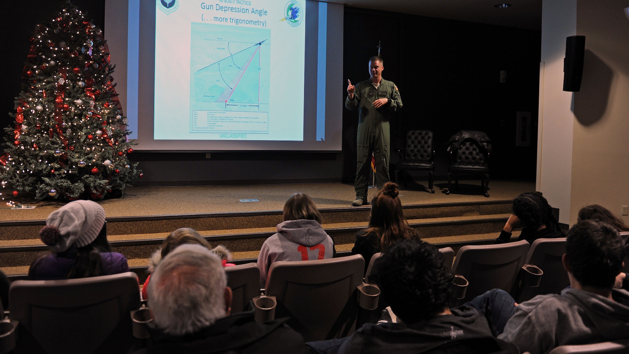 Capt. Daniel Sickles, 16th Special Operations Squadron Combat Systems officer, speaks to Portales High School Math Engineering and Science Achievement club members, Dec. 9, 2016, during a tour at Cannon Air Force Base, N.M. The tour, which consisted of an AC-130 technology brief and an in-depth look at a powered-on AC-130W, was designed to give students a practical look at real world math, engineering and science applications. (U.S. Air Force photo by Staff Sgt. Whitney Amstutz/Released)