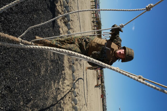 A recruit from Lima Company, 3rd Recruit Training Battalion, maneuvers across a rope obstacle during the Bayonet Assault Course at Marine Corps Recruit Depot San Diego, Dec. 27. The course helps recruits build a combat mindset as loud noises were played over the speaker to simulate noises encountered in combat. Annually, more than 17,000 males recruited from the Western Recruiting Region are trained at MCRD San Diego. Lima Company is scheduled to graduate Jan. 20.