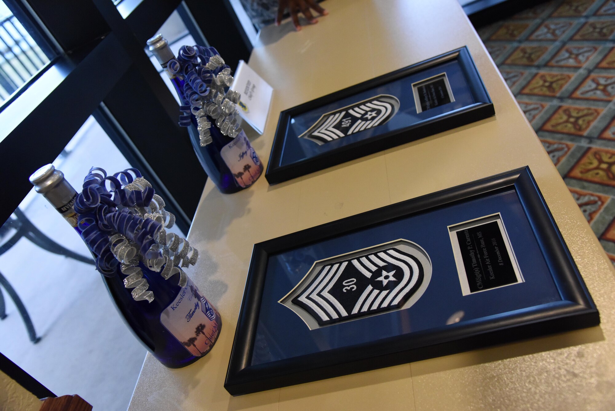 Promotion gifts sit on display during a chief master sergeant select recognition ceremony at the Bay Breeze Event Center Dec. 8, 2016, on Keesler Air Force Base, Miss. Base leadership recognized the three Keesler senior NCOs, Senior Master Sgts. Timothy Carentz, 81st Medical Operations Squadron superintendent, Jeffrey Bankoske, Mathies NCO Academy director of education, and Larry Jackson, 81st Operations Support Flight superintendent, for their selection to join the top 1 percent of the Air Force’s enlisted force. (U.S. Air Force photo by Kemberly Groue)

