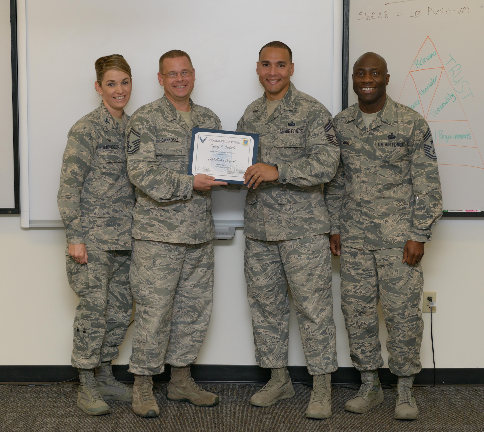 Col. Michele Edmondson, 81st Training Wing commander, Chief Master Sgt. Vegas Clark, 81st TRW command chief, and Chief Master Sgt. Rodney Deese II, Mathies NCO Academy commandant, congratulate Senior Master Sgt. Jeffrey Bankoske, Mathies NCOA director of education, on his selection to chief master sergeant at the Mathies NCOA Dec. 8, 2016, on Keesler Air Force Base, Miss. Base leadership visited the work centers of three Keesler senior NCOs to recognize and congratulate them on joining the top 1 percent of the Air Force’s enlisted force.  (U.S. Air Force photo by Andre’ Askew)
