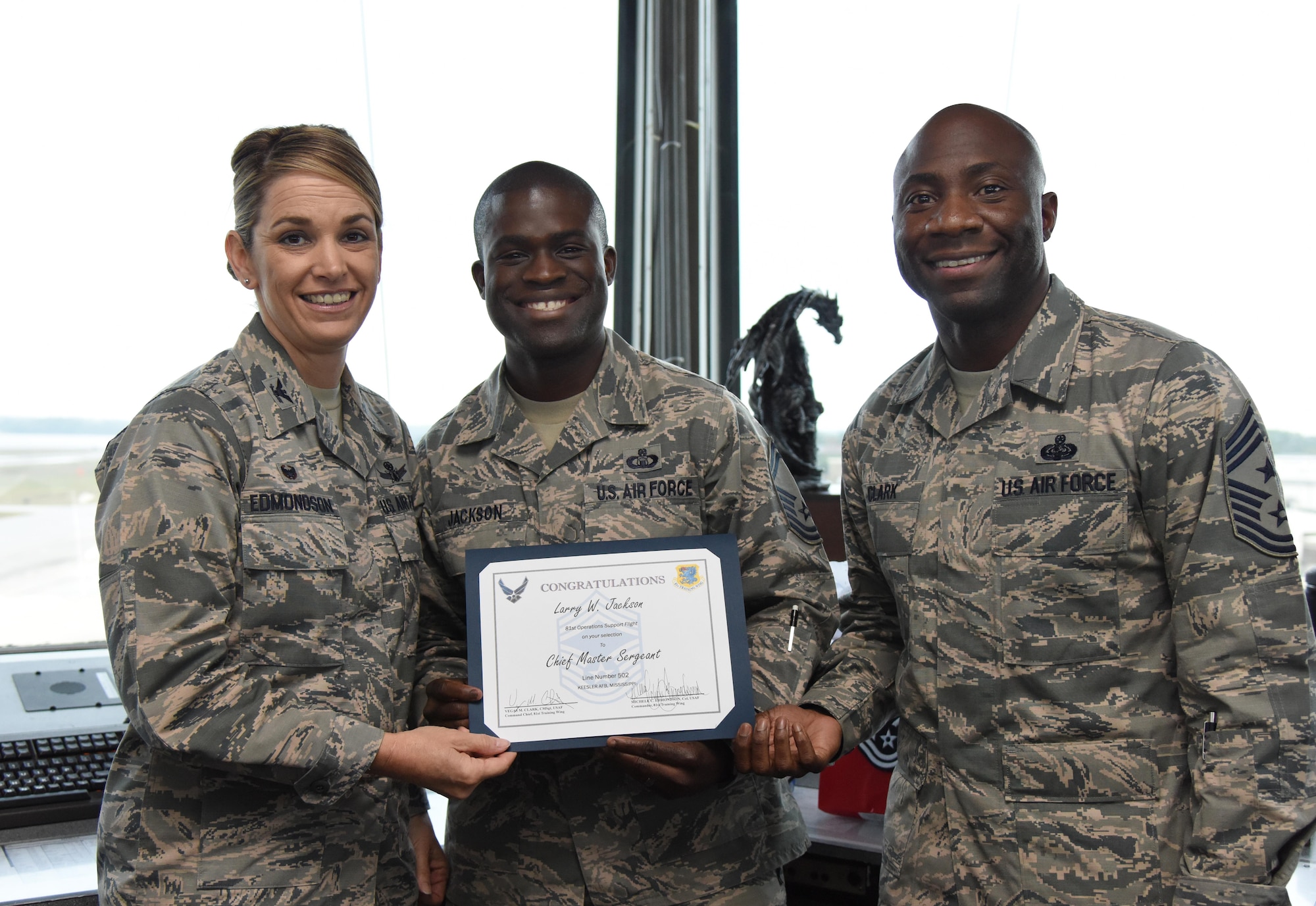 Col. Michele Edmondson, 81st Training Wing commander, and Chief Master Sgt. Vegas Clark, 81st TRW command chief, congratulate Senior Master Sgt. Larry Jackson, 81st Operations Support Flight superintendent, on his selection to chief master sergeant at the air traffic control tower Dec. 14, 2016, on Keesler Air Force Base, Miss. Base leadership visited the work centers of three Keesler senior NCOs to recognize and congratulate them for their selection to join the top 1 percent of the Air Force’s enlisted force. (U.S. Air Force photo by Kemberly Groue)