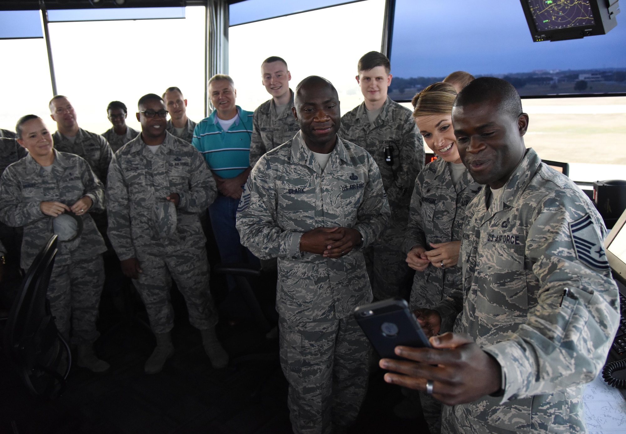 Chief Master Sgt. Vegas Clark, 81st Training Wing command chief, and Col. Michele Edmondson, 81st TRW commander, watch as Senior Master Sgt. Larry Jackson, 81st Operations Support Flight superintendent, notifies his spouse on his selection to chief master sergeant at the air traffic control tower Dec. 14, 2016, on Keesler Air Force Base, Miss. Base leadership visited the work centers of three Keesler senior NCOs to recognize and congratulate them for their selection to join the top 1 percent of the Air Force’s enlisted force. (U.S. Air Force photo by Kemberly Groue)