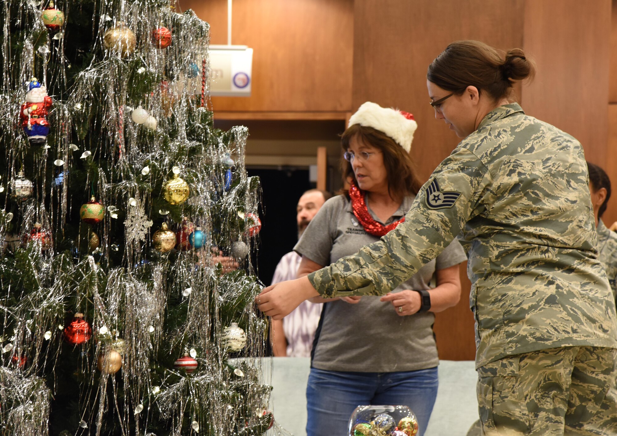 Barbara Walker, 335th Training Squadron training specialist, and Staff Sgt. Leanne Kirk, 81st Medical Group medical administrator, examine Christmas tree ornaments at the Armed Forces Retirement Home Dec. 29, 2016, Gulfport, Miss. Keesler Air Force Base personnel donated and delivered more than 66 gifts to residents at the home through the Adopt A Veteran program. (U.S. Air Force photo by Kemberly Groue)