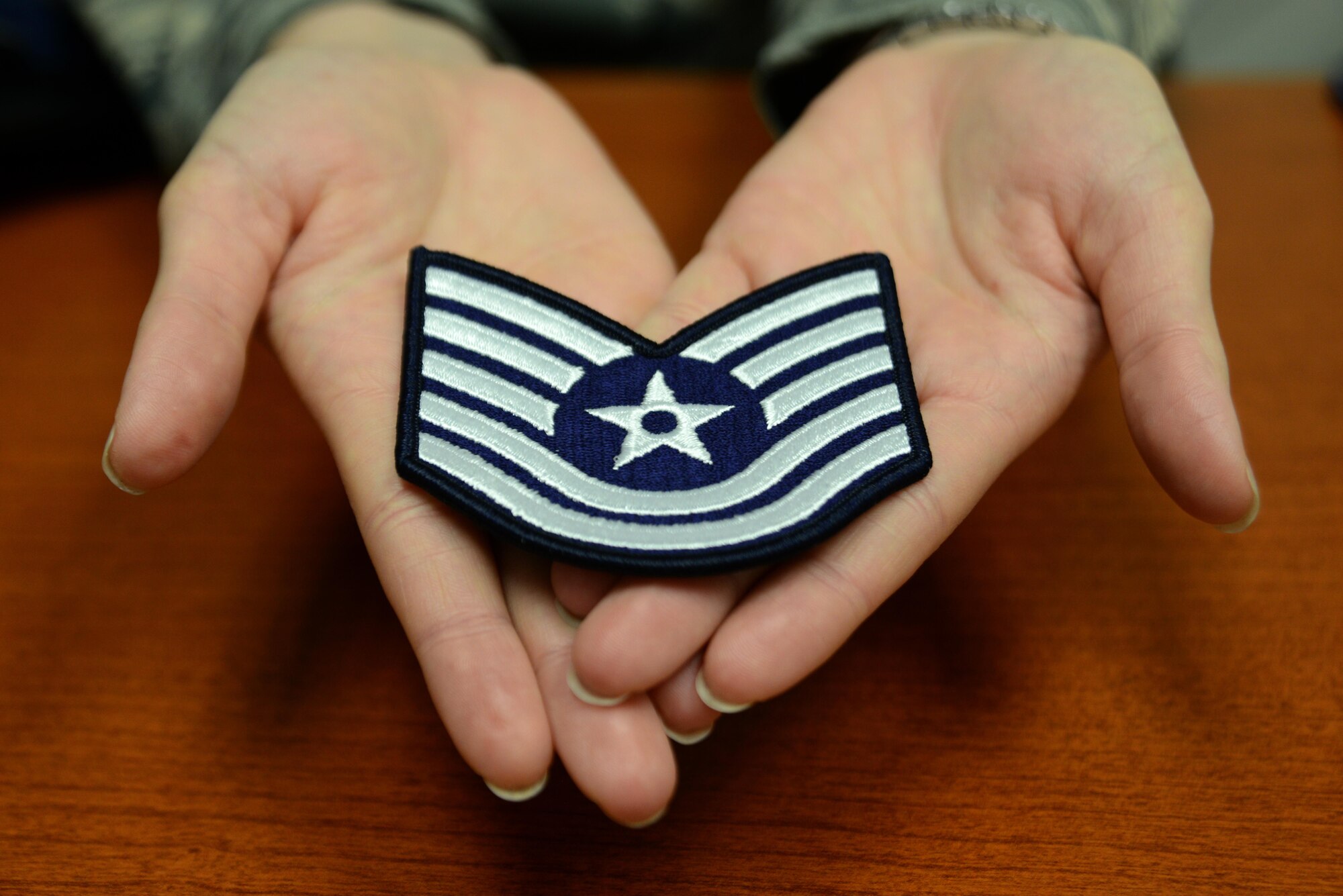 Technical Sgt. Jessica Tabor, 673d Equal Opportunity noncommissioned officer in charge, holds her recently earned technical sergeant stripes at Joint Base Elmendorf-Richardson, Alaska, Dec. 29, 2016. She dedicated her promotion to her late supervisor because she said she earned them through his teachings and guidance.