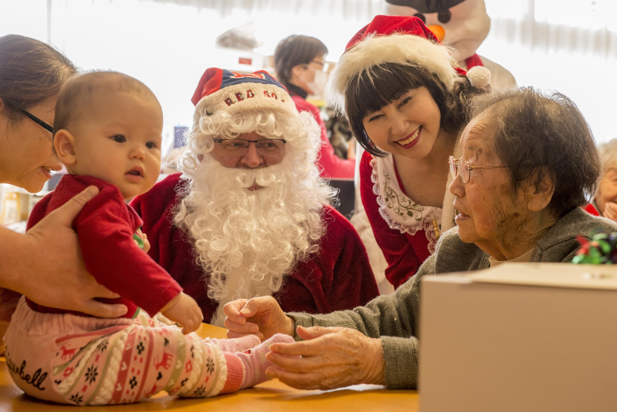 A Yokota Air Base volunteer’s child visits with residents of the Fussa Kotobuki Garden Nursing Home alongside Santa Claus during a Christmas Eve visit on Dec. 24, 2016, in Fussa, Tokyo, Japan. During visits throughout the years to the Fussa Kotobuki Garden Nursing Home, volunteers have arranged various activities such as the Christmas Eve visits, barbecue lunches, taking residents for walks along the nearby Tama River or going to simply sit and talk with them. (U.S. Air Force photo by Airman 1st Class Donald Hudson)