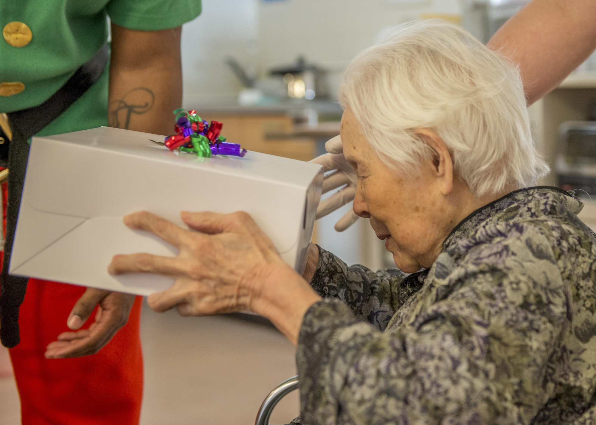 A resident of the Fussa Kotobuki Garden Nursing Home receives a present during a Christmas Eve visit on Dec. 24, 2016, in Fussa, Tokyo, Japan. Volunteers from Yokota Air Base’s Community Center Outreach Program visit the Kotobuki Garden Nursing Home multiple times a year to visit with the residents to provide positive and caring outreach opportunities in the local community. (U.S. Air Force photo by Airman 1st Class Donald Hudson)