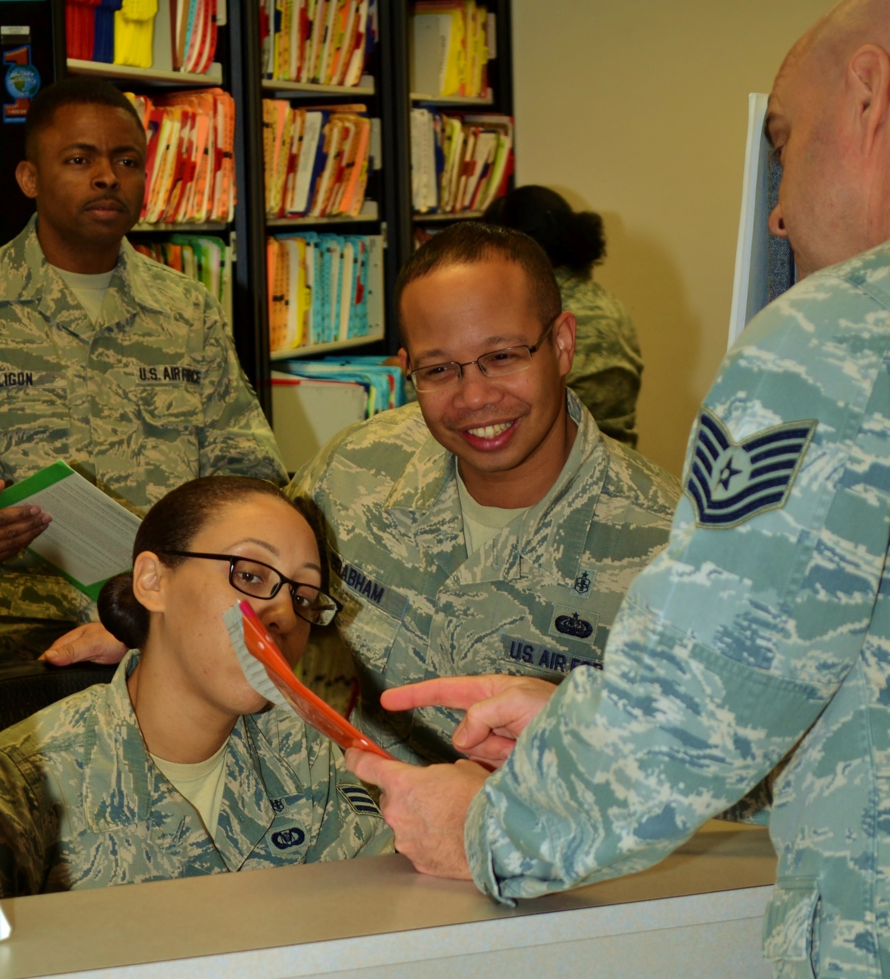 Master Sgt. Roberto Brabham, center, a 111th Medical Group health systems technician, helps a customer at the 111th Attack Wing Medical Clinic, Horsham Air Guard Station, Pa., Dec. 22, 2016. Brabham assists in executing the Wing vision of Air Force compliance, mission excellence and Airmen wellness. (U.S. Air National Guard photo by Tech. Sgt. Andria Allmond/Released)