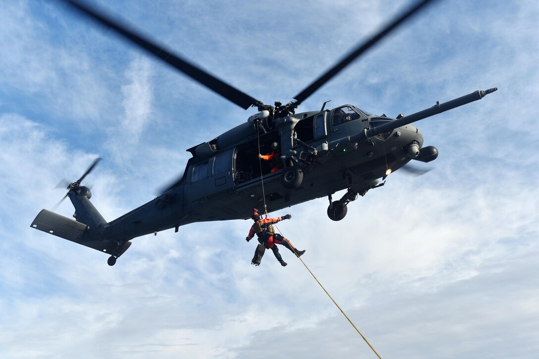 An HH-60 Pave Hawk helicopter hoists a Coast Guardsman during training in Hampton Bays, N.Y., Dec. 22, 2016. Air National Guard photo by Staff Sgt. Christopher S. Muncy