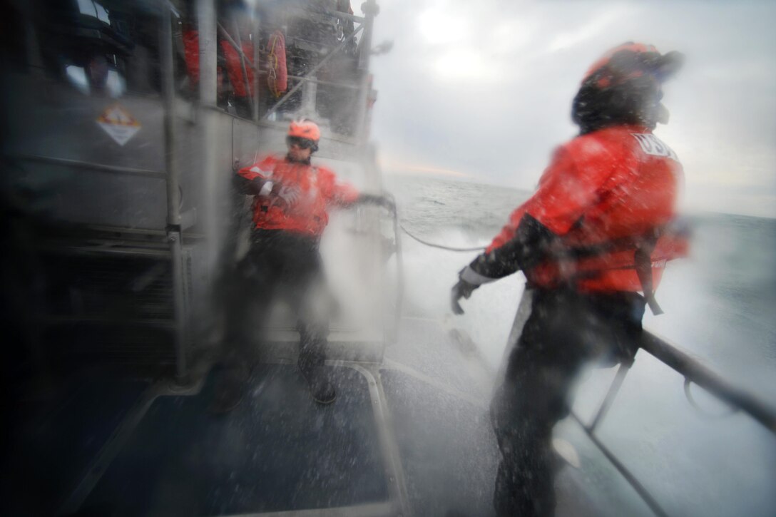 Coast Guardsmen brace themselves as heavy waves wash against a cutter during training in the waters near Coast Guard Station Shinnecock in Hampton Bays, N.Y., Dec. 22, 2016. Air National Guard photo by Staff Sgt. Christopher S. Muncy
