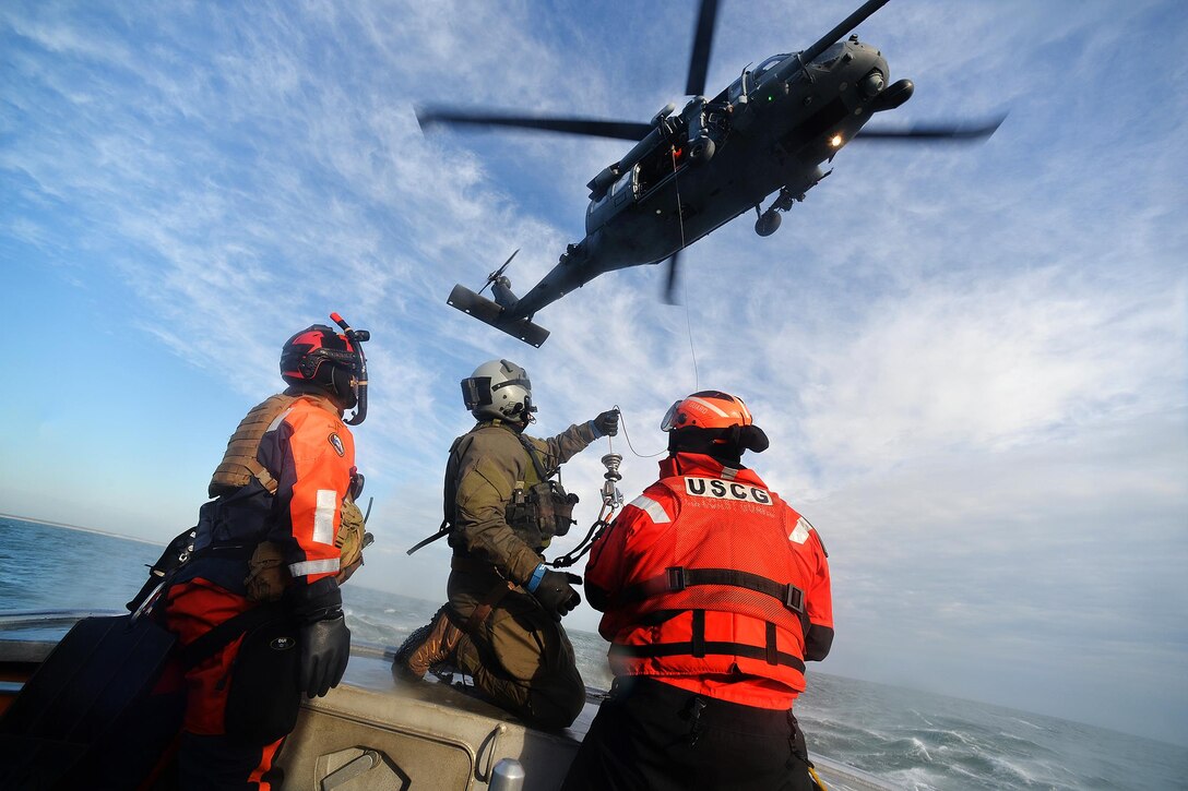 Airmen and Coast Guardsmen discuss hoist training in the waters near Coast Guard Station Shinnecock in Hampton Bays, N.Y., Dec. 22, 2016. Air National Guard photo by Staff Sgt. Christopher S. Muncy