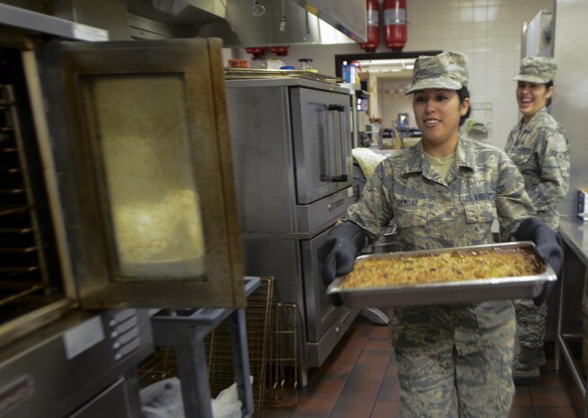 U.S. Air Force Airman 1st Class Gloria Rembao, 628th Force Support Squadron flight kitchen shift leader, carries a tray to the serving line during Christmas dinner at the Gaylor Dining Facility Dec. 25, 2016. Base leadership and their families helped serve Airmen Christmas dinner.