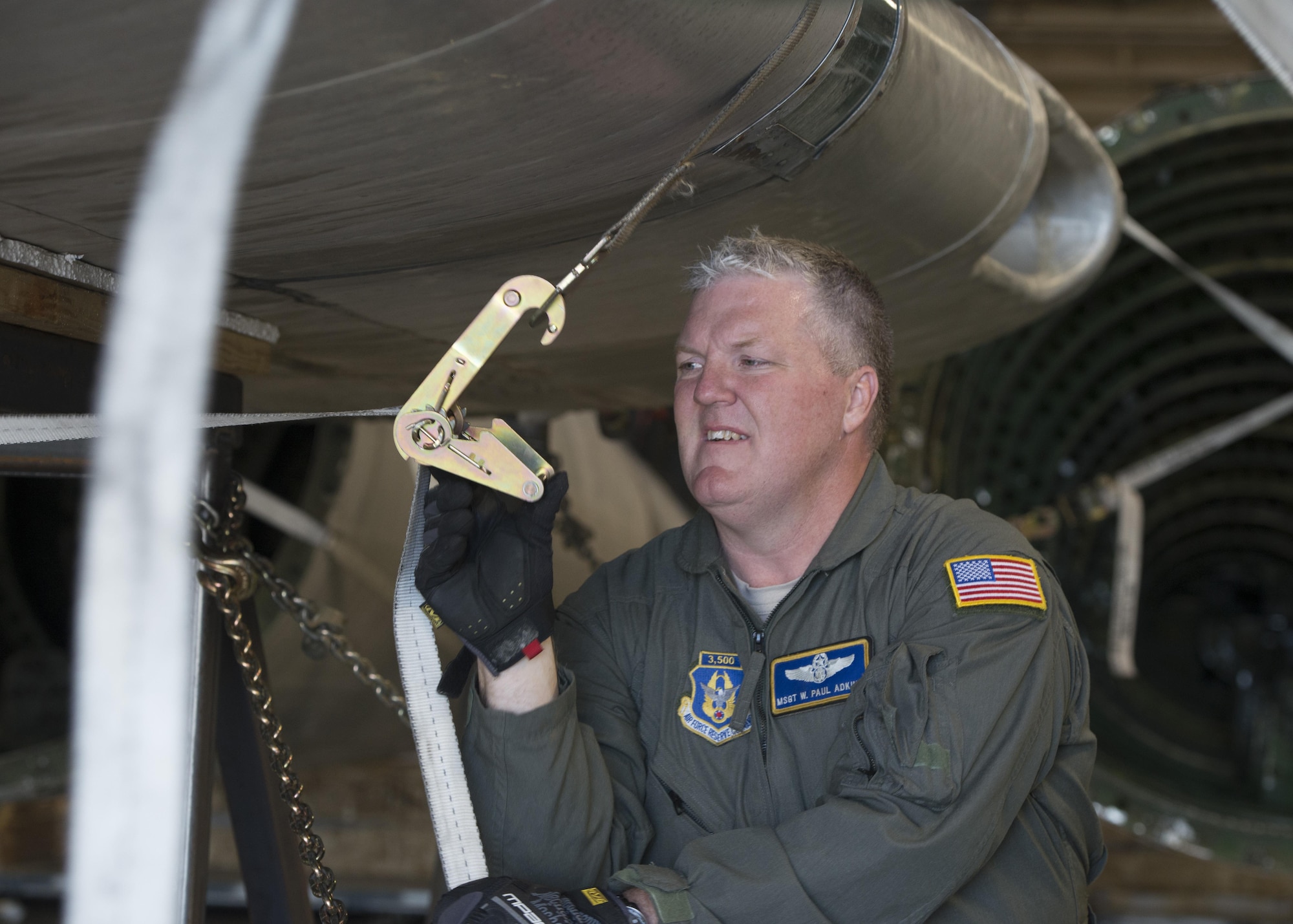 Master Sgt. Paul Adkins, 709th Airlift Squadron loadmaster, straps down the wings of the Fairchild C-119B Flying Boxcar #48-0352 “Am Can Co Special” inside a C-5M Super Galaxy Dec. 19, 2016, at Edwards Air Force Base, Calif. Adkins is an experienced loadmaster with more than 3,500 flight hours. (U.S. Air Force photo by Senior Airman Zachary Cacicia)