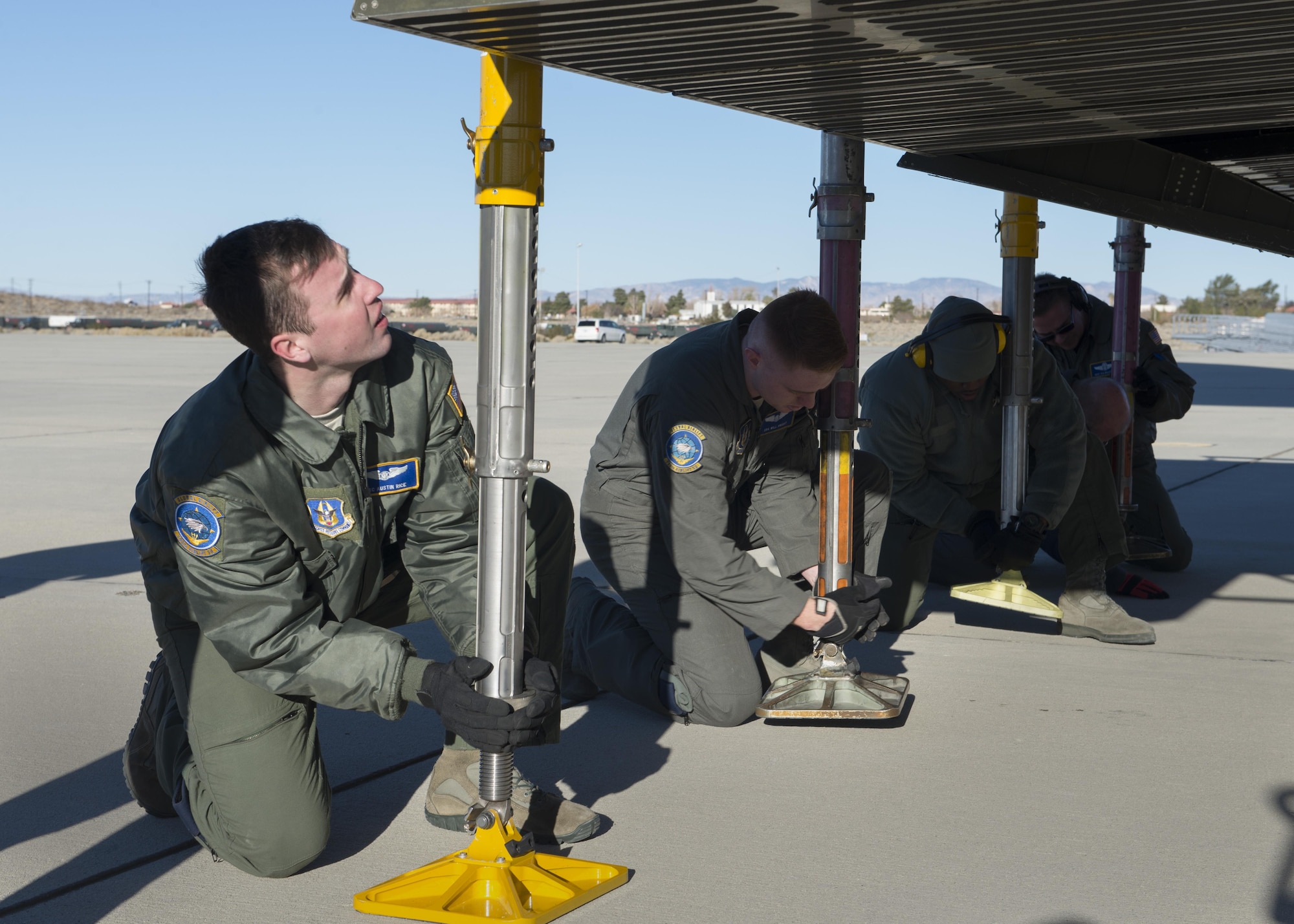 Loadmasters from the 709th Airlift Squadron deploy jack pads from the forward cargo ramp of a C-5M Super Galaxy Dec. 19, 2016, at Edwards Air Force Base, Calif. The jack pads support the weight of cargo as it is loaded onto the forward ramp. (U.S. Air Force photo by Senior Airman Zachary Cacicia)