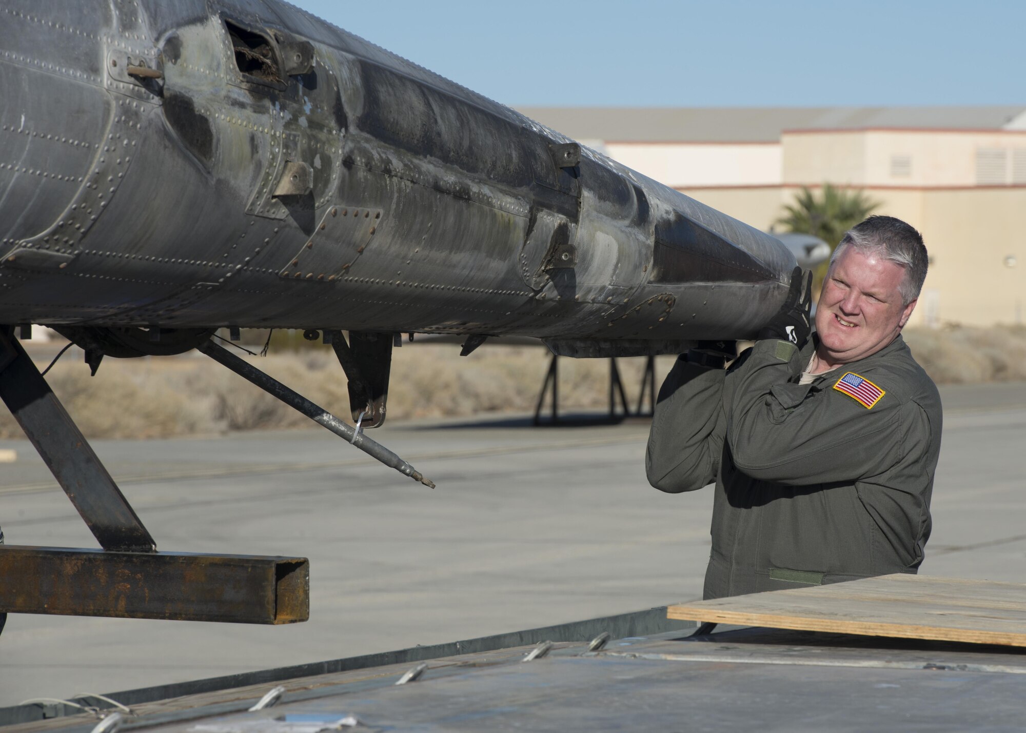 Master Sgt. Paul Adkins, 709th Airlift Squadron loadmaster, lifts a tail-boom from the Fairchild C-119B Flying Boxcar #48-0352 “Am Can Co Special” during a mission to bring it to the Air Mobility Command Museum via a C-5M Super Galaxy airlifter Dec. 17, 2016, at Edwards Air Force Base, Calif. C-119 are a twin tail-boomed cargo aircraft. (U.S. Air Force photo by Senior Airman Zachary Cacicia)