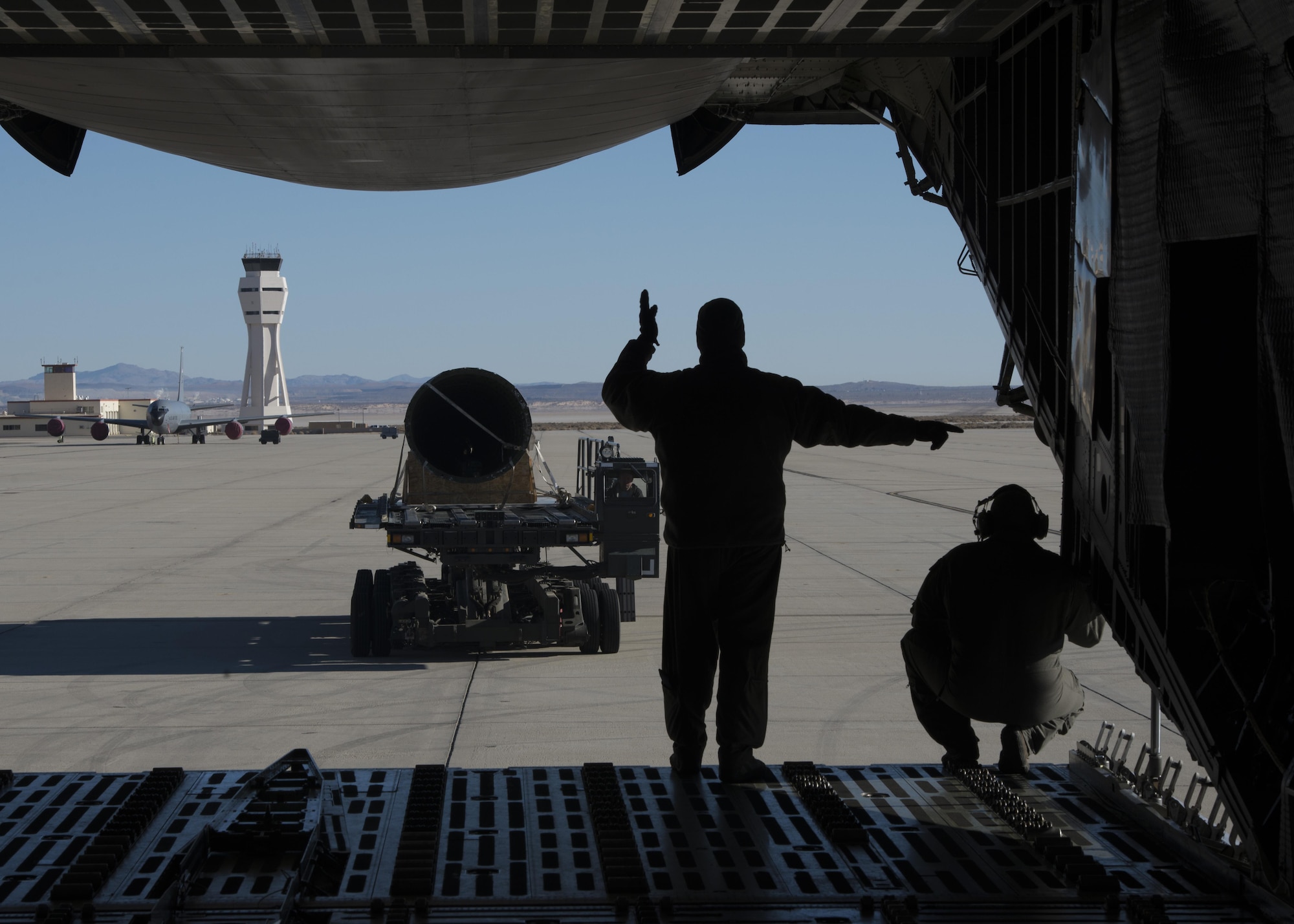 Master Sgt. Paul Adkins, 709th Airlift Squadron loadmaster, and Master Sgt. Bryan Muise, 709th AS loadmaster, martial a K-Loader, carrying a tail-boom from the Fairchild C-119B Flying Boxcar #48-0352 “Am Can Co Special,” toward the rear-cargo entrance of a C-5M Super Galaxy Dec. 19, 2016, at Edwards Air Force Base, Calif. This C-119 will be arguably the most historic aircraft in the Air Mobility Command Museum’s collection. (U.S. Air Force photo by Senior Airman Zachary Cacicia)