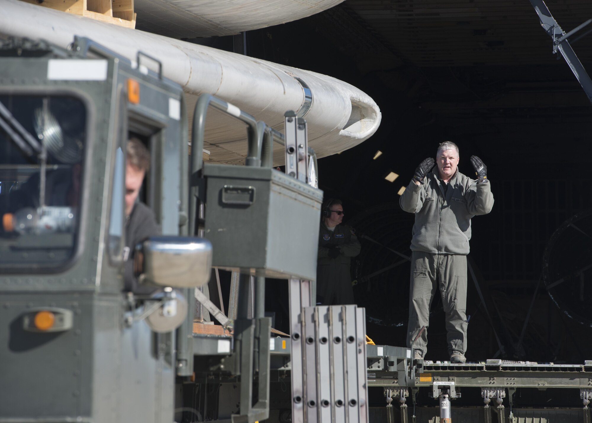 Master Sgt. Paul Adkins, 709th Airlift Squadron loadmaster, martials a K-Loader, carrying the wings of the Fairchild C-119B Flying Boxcar #48-0352 “Am Can Co Special,” toward the forward cargo entrance of a C-5M Super Galaxy Dec. 19, 2016, at Edwards Air Force Base, Calif. Once restored, the C-119 will be on display at the Air Mobility Command Museum on Dover AFB, Del. (U.S. Air Force photo by Senior Airman Zachary Cacicia)