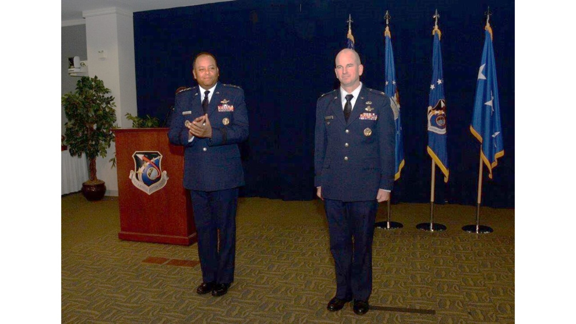 Lt. Gen. Samuel Greaves, commander of the Space and Missile Systems Center, and program executive officer for Space leads the audience in applauding Col. Dennis Bythewood, who assumed command of the Remote Sensing Systems Directorate Dec. 19, during a change of leadership ceremony in the Gordon Conference Center of the Schriever Space Complex at Los Angeles Air Force Base in El Segundo, Calif. (U.S. Air Force photo/Van De Ha)