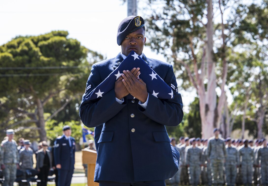 Airman 1st Class Kelly Goodwin, 60th Security Forces Squadron, carries the American flag following a retreat ceremony at Travis Air Force Base, Calif., May 20, 2016. During the ceremony, the names of eight security forces and Air Force Office of Special Investigations Airmen were read aloud, signifying their "end of watch." (U.S. Air Force photo by Staff Sgt. Charles Rivezzo)